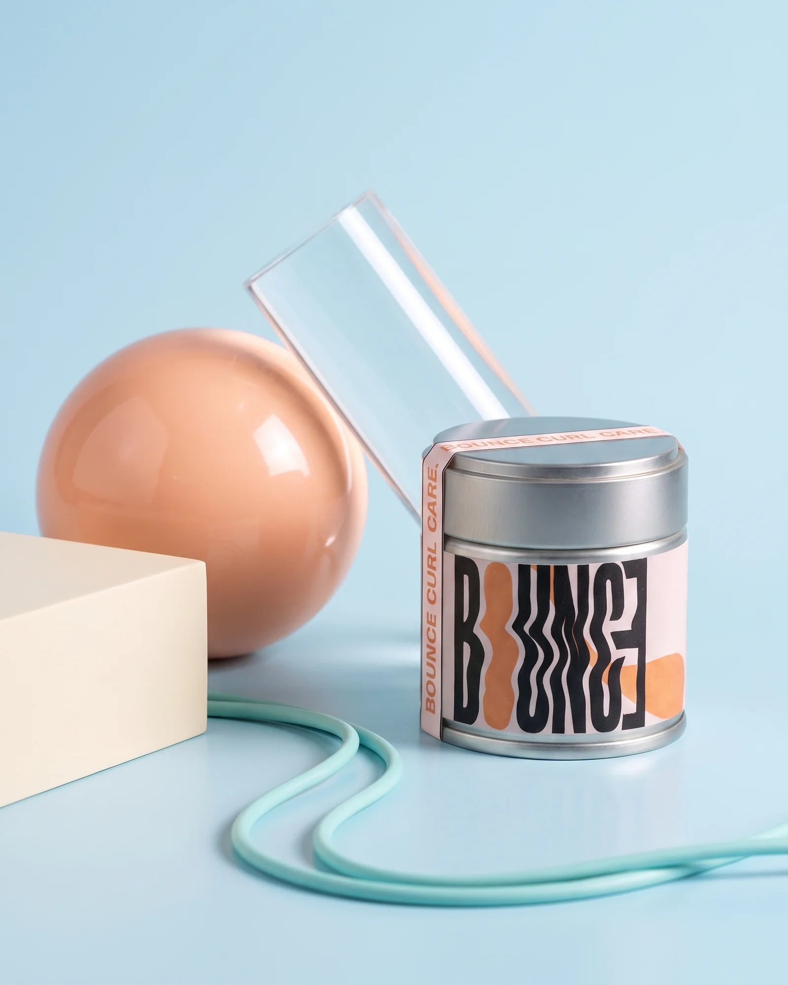 A Bounce Curl Care tin styled with sculptural props